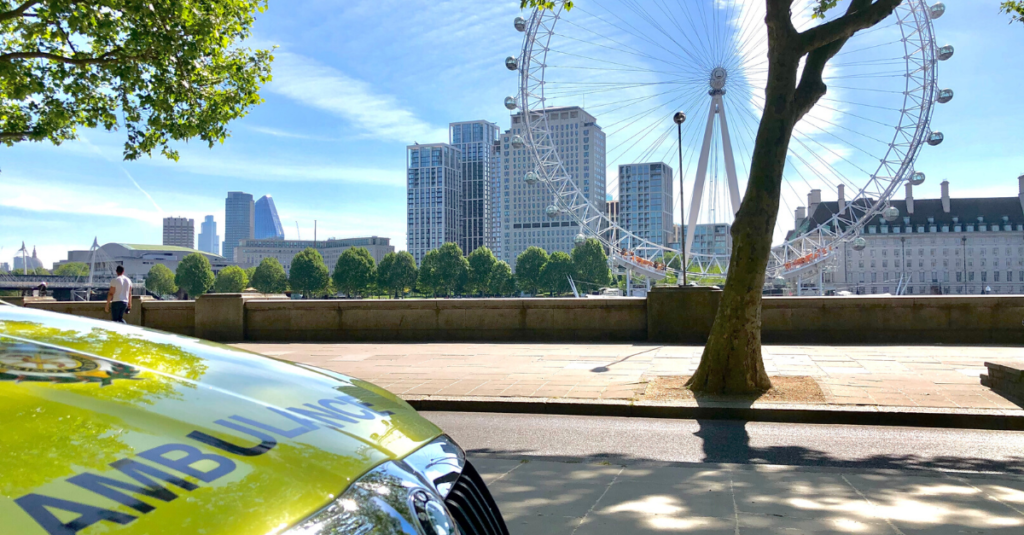 ambulance car parked with London Eye and blue skies in background