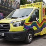 Picture of a London Ambulance with the Pride flag decorated on the front and side.
