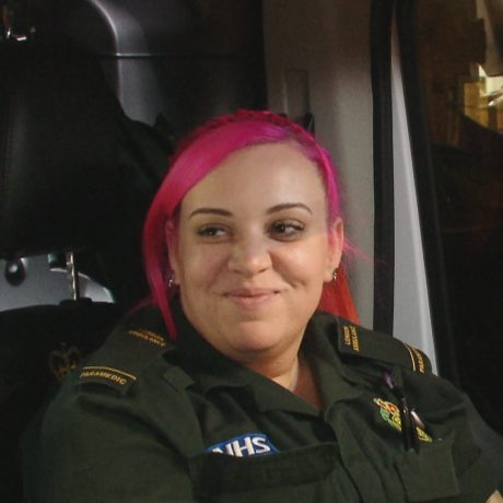 Jade smiling whilst sat in the front of the ambulance with Ellis. 