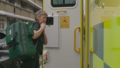 Ambulance clinician carrying equipment back into their ambulance. 