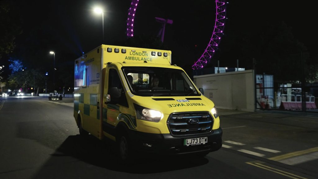 An electric ambulance in front of the London Eye.